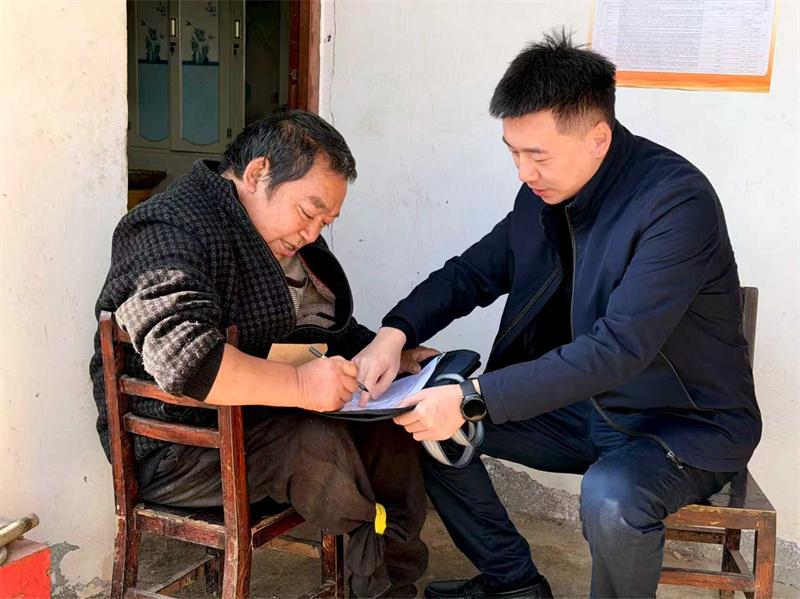 胡彧之（右）到村民家了解家庭情況。青川縣融媒體中心供圖