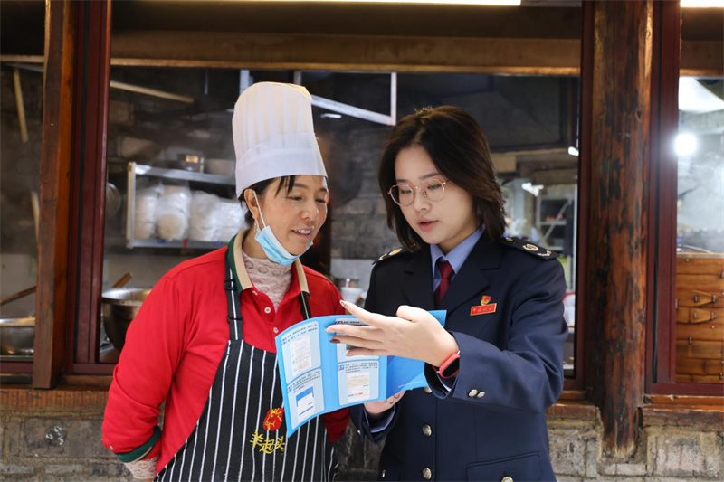 税务干部到特色餐饮企业进行税费优惠政策宣传。王星入供图