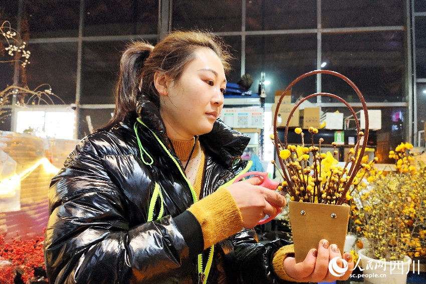 瑾岚鲜花的店主江雪丽正忙着为腊梅花花篮修枝。人民网记者 朱虹摄