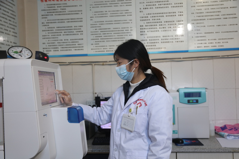 技术人员将采集血液送入血常规机器。马发海摄