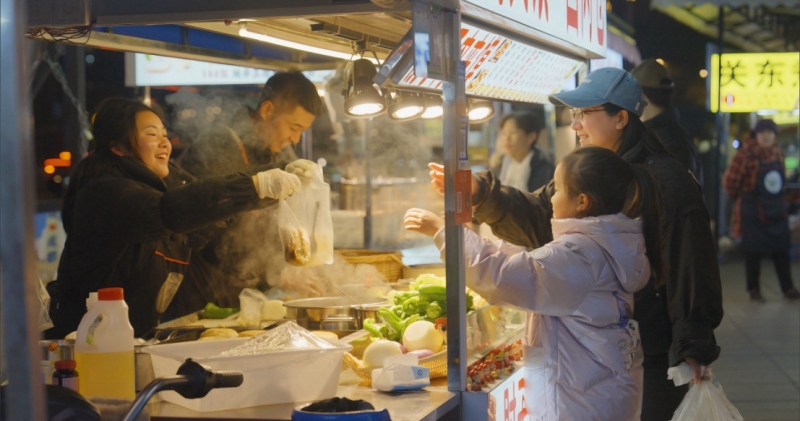 市民正在夜市摊位购买东西。成都城管委供图