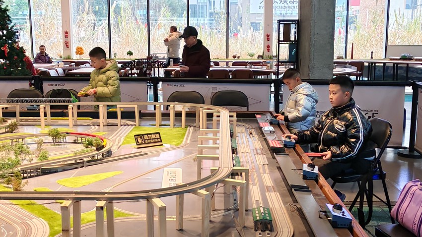 小朋友們在火車模型沙盤前操作著列車模型。實習生 郭悠然攝