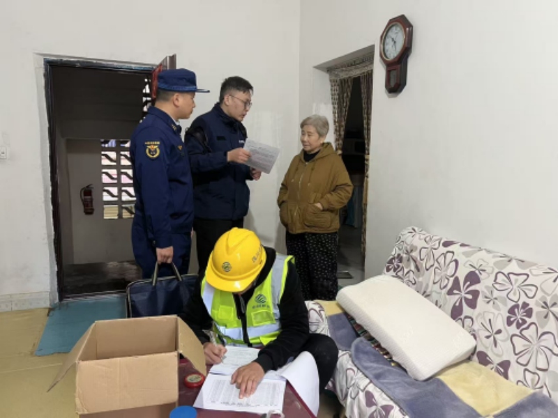 工作人员向住户宣讲报警器注意事项。绵阳市消防救援支队供图