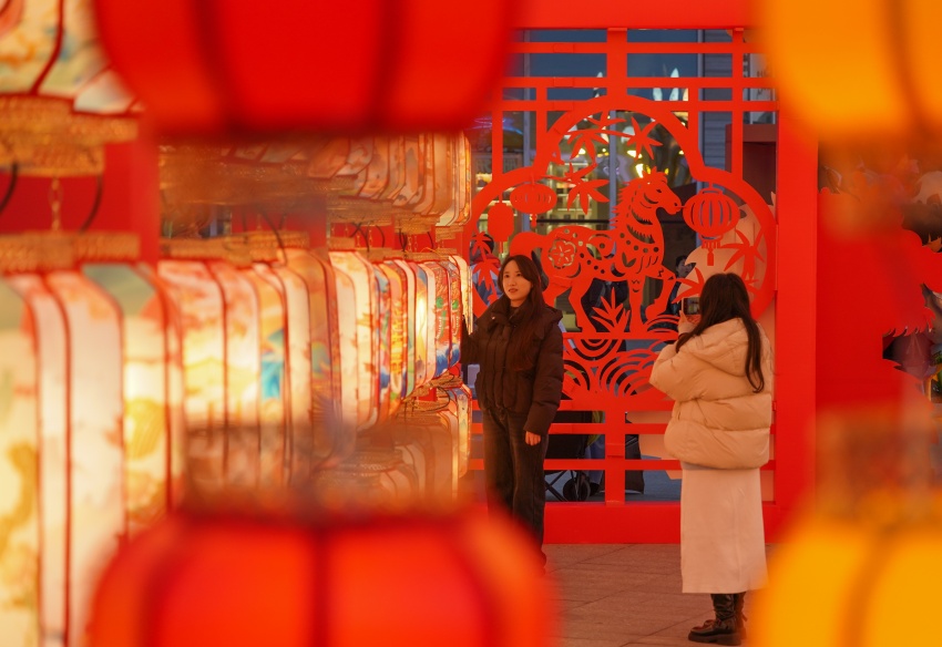 在眉山市彭山区，市民在带有马年元素的彩灯旁拍照打卡。翁光建摄