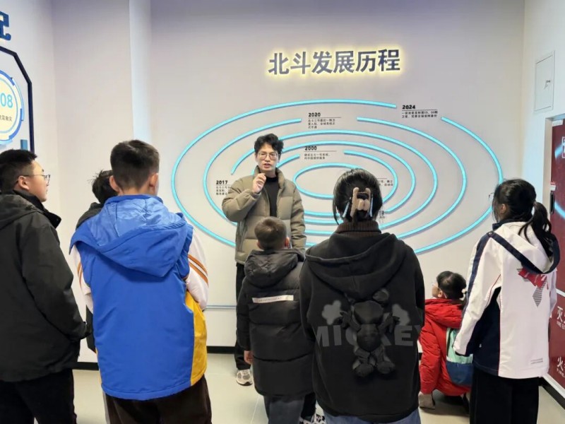 听讲解员介绍北斗卫星的发展历程。四川天府新区融媒体中心供图