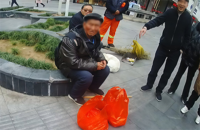 赶地铁来资阳买20斤猪肉的62岁老人，在资阳家乐福商圈迷路后，坐在路边花台上等待民警前来救助，红色口袋系老人所购猪肉。资阳市公安局供图