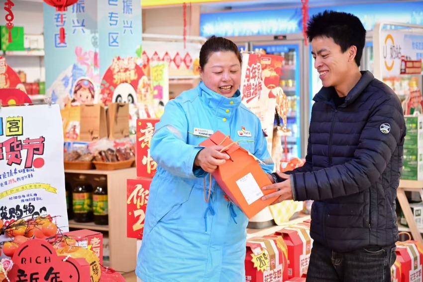 成都分公司新都中心站北新加油站巴长赖丽热情为返乡顾客推介地方特色好物，让这一份团圆更有温度。胡伟摄