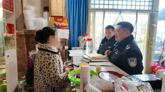 民警李沈（左一）上門向收銀員了解情況。資陽市公安局供圖