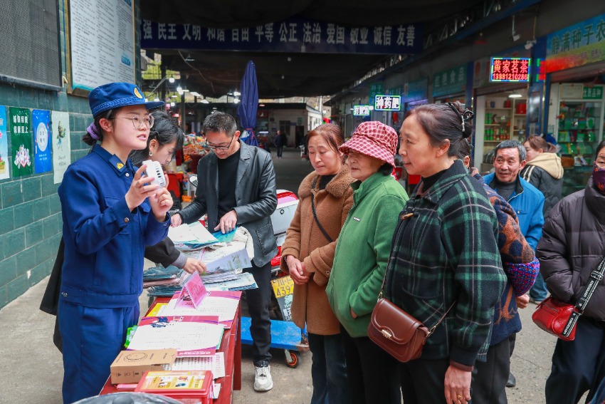 消防宣传人员与志愿者摆摊设点、发放宣传资料。广元市消防救援局供图