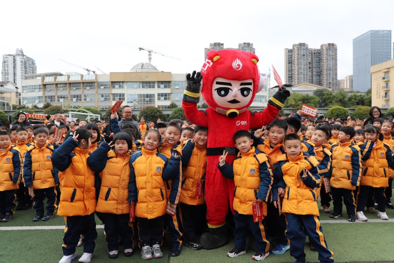 在遂宁遂州外国语学校，学生与吉祥物合影。遂宁市消防救援支队供图