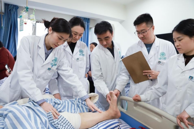 成都風濕醫院痛風科門診主任團隊正在檢查病人情況。成都風濕醫院供圖