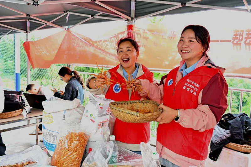 駐村干部在鏡頭前展示農產品。周璘攝
