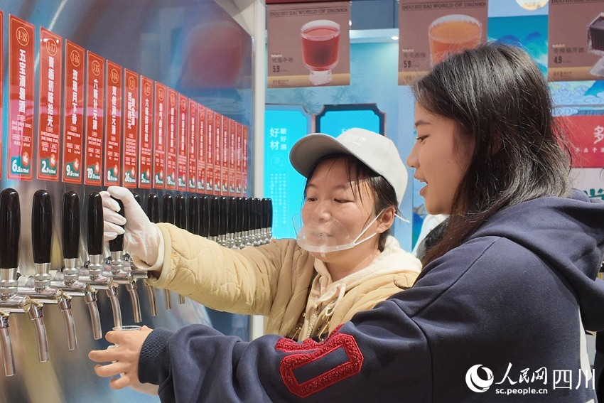 酒博会现场，参观者在完成潮玩游戏后，免费品尝特色美酒。人民网 赵祖乐摄