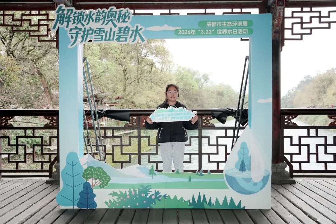 小小摄影爱好者们手持精心设计的承诺卡，在打卡墙前合影。主办方供图