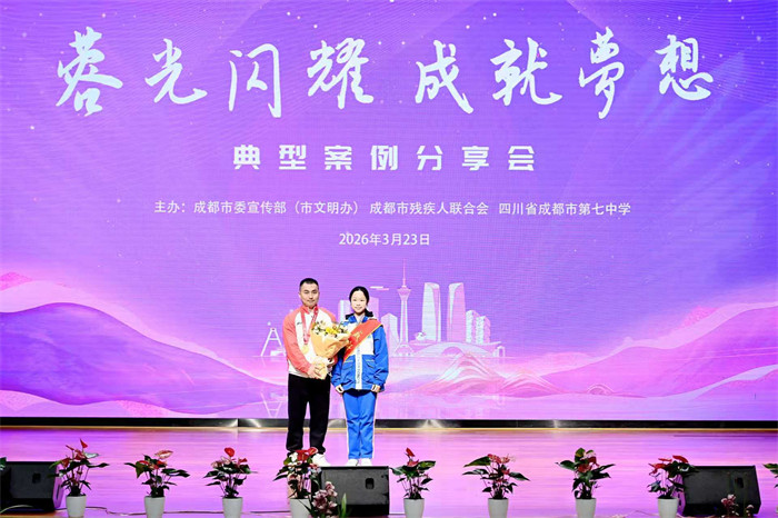 中国残疾人羽毛球队教练黄永根与学生代表合影。主办方供图