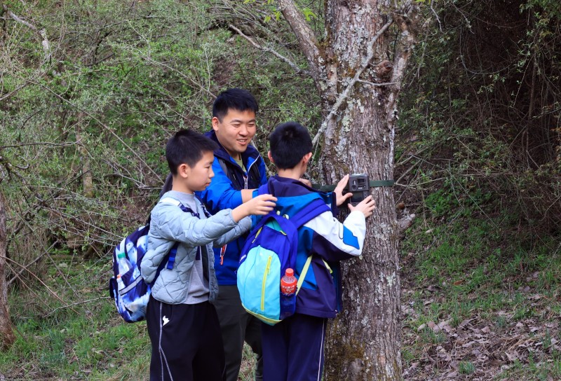 带队老师和学生安装红外线相机。广元市融媒体中心供图