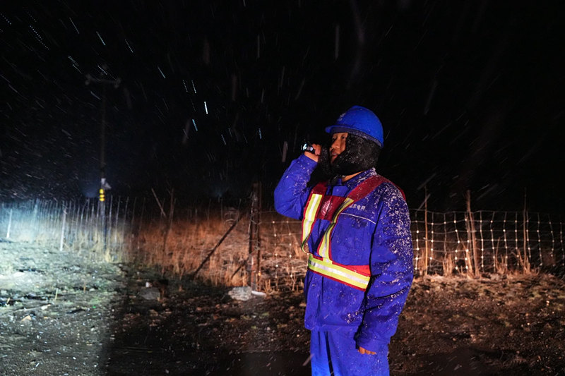 国网阿坝供电公司输电运检人员冒着风雪，对110千伏马龙线开展夜间巡视。张懿玲摄