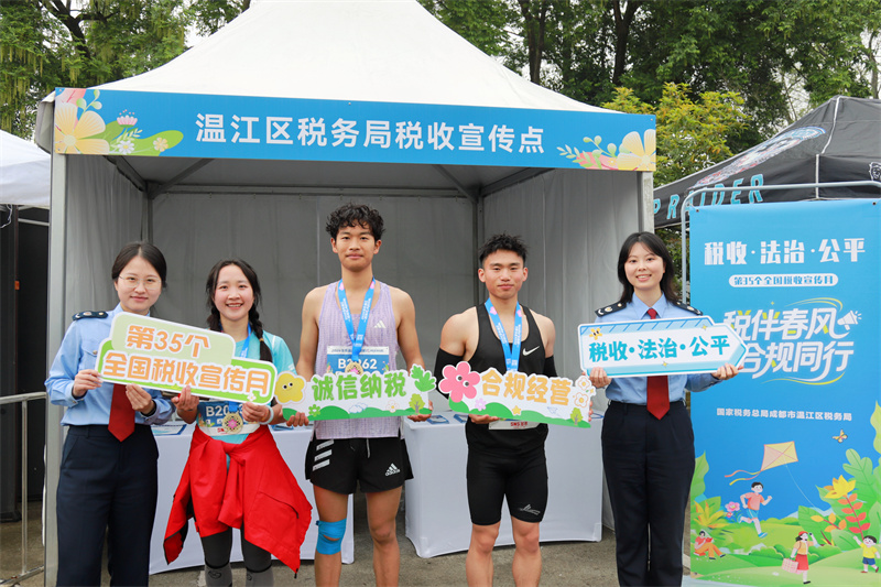温江区税务局在“一路繁花”快乐村跑现场进行税收宣传。成都市税务局供图