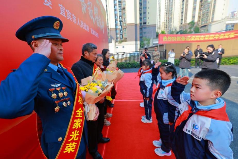 少先队员向荣获中央军委一级表彰的叙州区现役军人张运虎献花和敬礼。宜宾市退役军人事务局供图