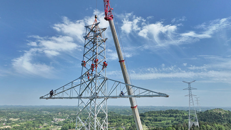 在四川简阳云龙镇庄园社区礼帽山，建设者正在进行空港—淮州双回500kV线路工程NC21铁塔组立。陈翔摄
