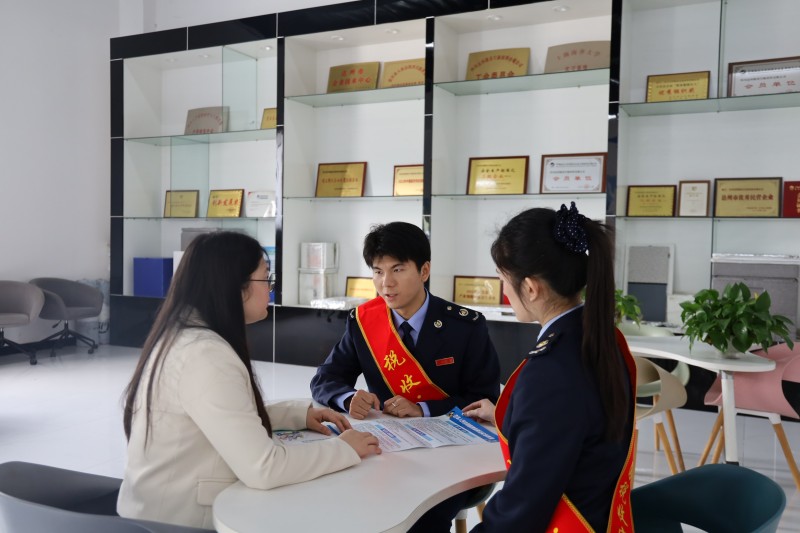 税务干部向企业人员宣传税费政策。达州市税务局供图