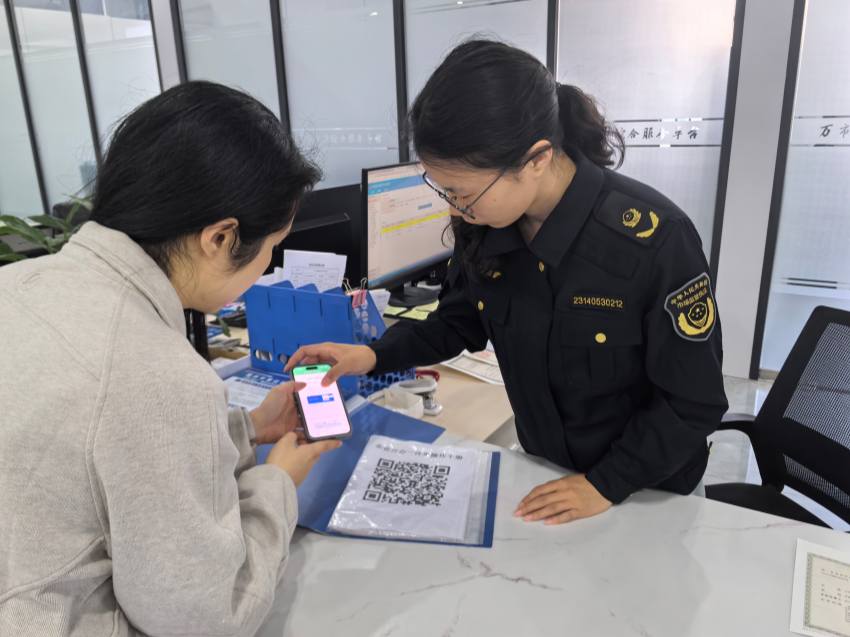 工作人员现场指导群众扫码自助办理业务。邬忠瑜摄