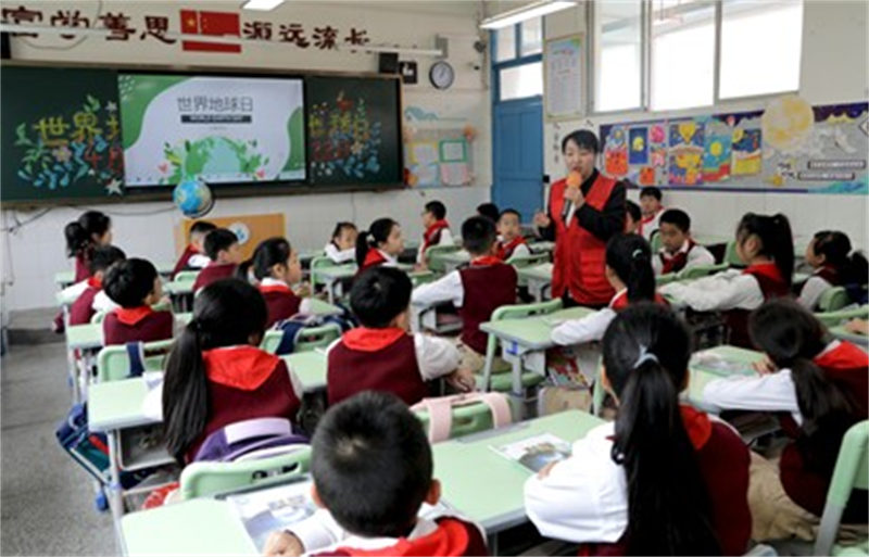 4月22日，在广安市广安区富源小学，广福街道西溪社区环保志愿者在给孩子们普及环境保护知识。