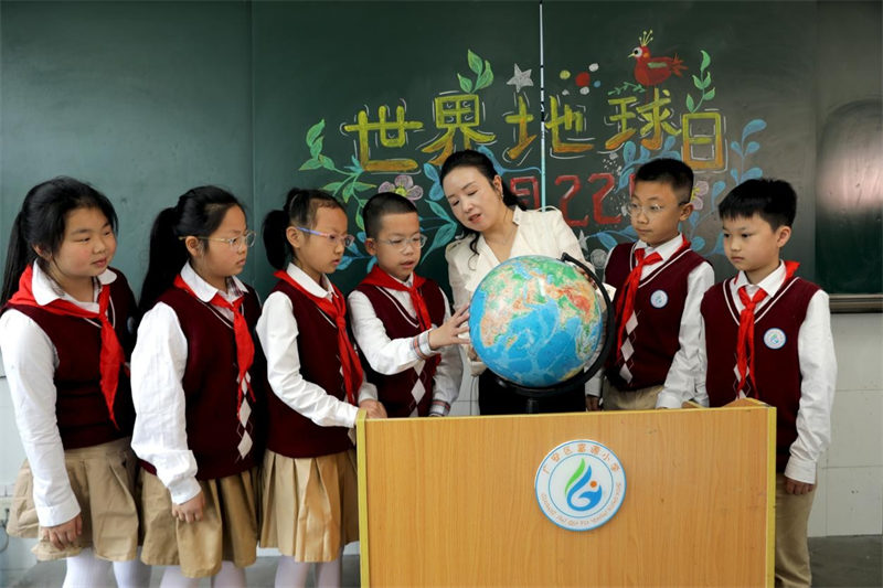 4月22日，在广安市广安区富源小学，老师指导孩子们认识地球仪。
