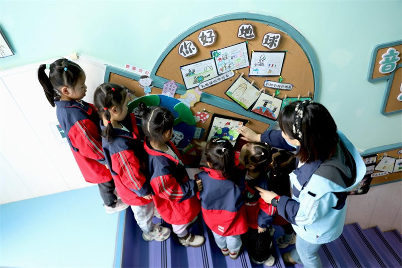 4月22日，在四川省广安市广安区岩头幼儿园，老师指导孩子们通过地球小知识创意橱窗认识地球