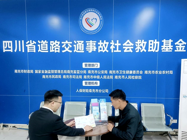 工作人员协助群众申请道交基金救助。人保财险南充市分公司供图