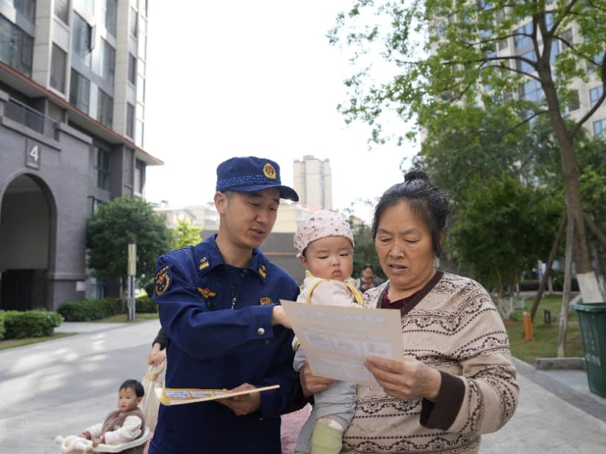 消防员为小区居民发放宣传资料。广元市消防救援局供图