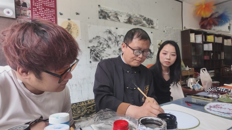 游客学习画扇面。昭化区融媒体中心供图