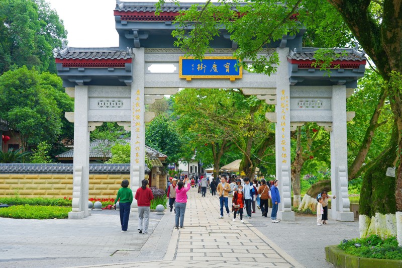 游人漫步宝庆街，两旁的黄桷树投下斑驳的光影，晕染出闲适而鲜活的市井气息。乐山市融媒体中心供图