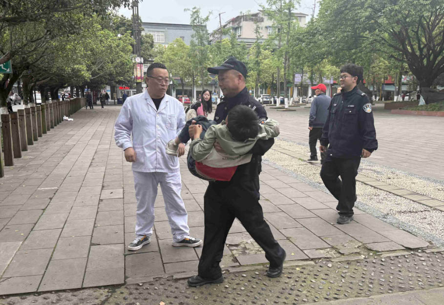 民警曾刚林抱受伤孩童前往救护车。成都新都公安供图