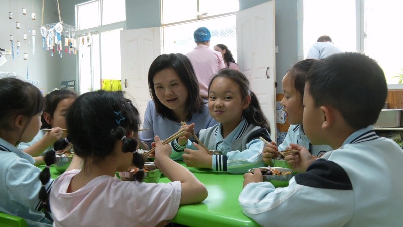 学生家长和孩子们一起吃午饭。朝天区融媒体中心供图