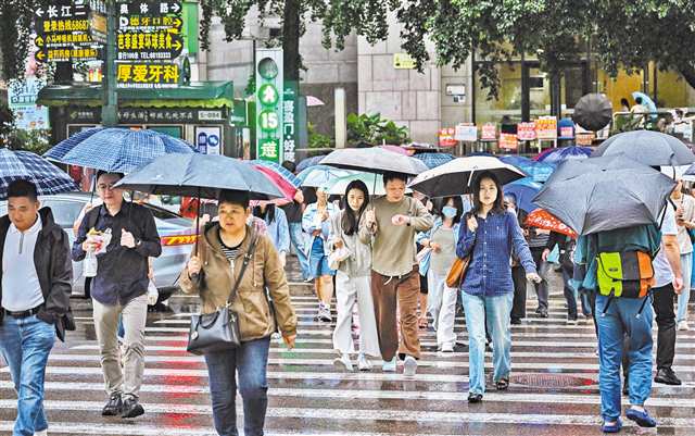 6月8日晨,重庆中心城区降雨持续。图为渝中区奥体路,市民撑着伞过人行道。记者 张锦辉 摄/视觉重庆