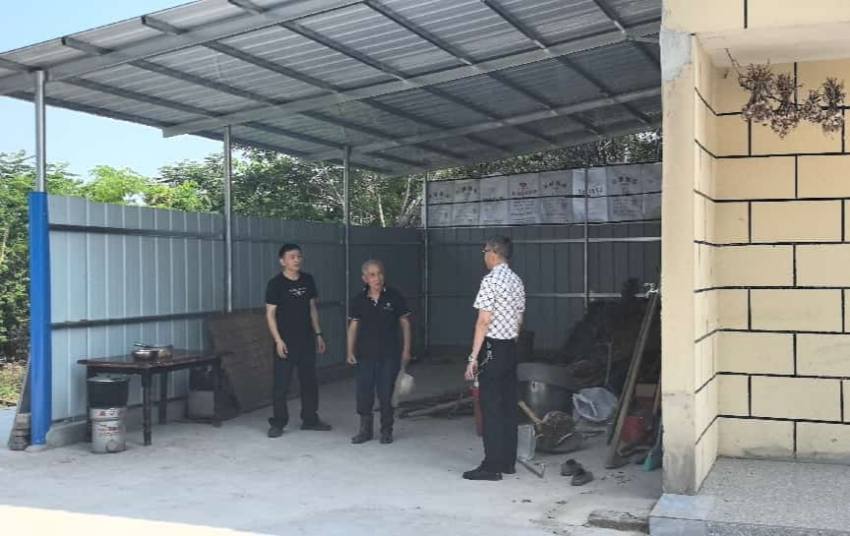 邓刚（左一）在余仲谋重建后的柴房现场。四川省水电集团供图