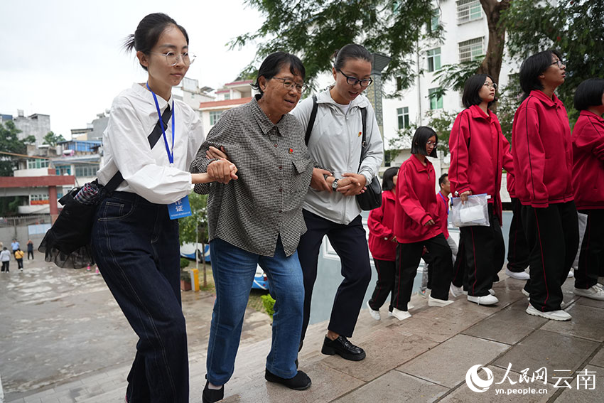 6月8日,张桂梅在同事的搀扶下,陪同考生前往休息区。人民网记者 李发兴摄