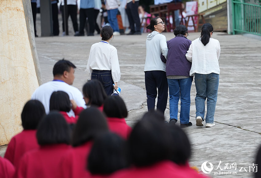 6月9日,张桂梅在同事的搀扶下带领考生前往考场。人民网记者 李发兴摄