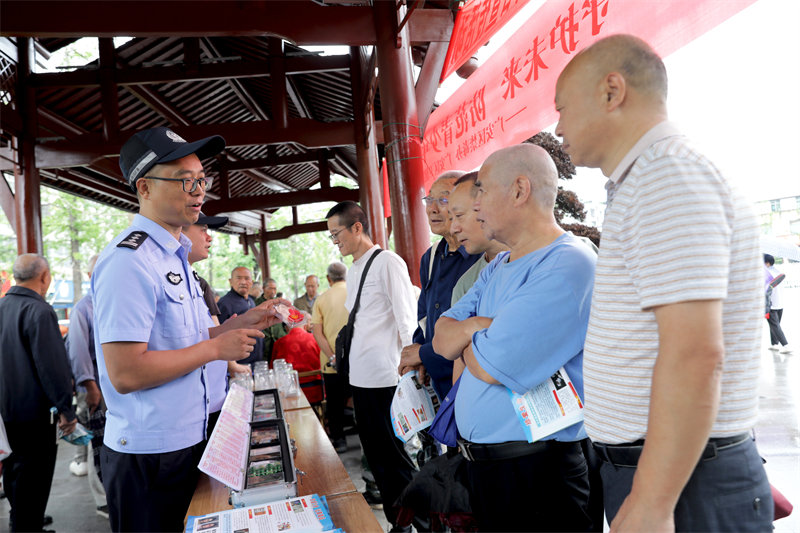 在广安市广安区北辰街道北辰湖公园，民警通过展示仿真毒品模型给居民讲解禁毒知识。