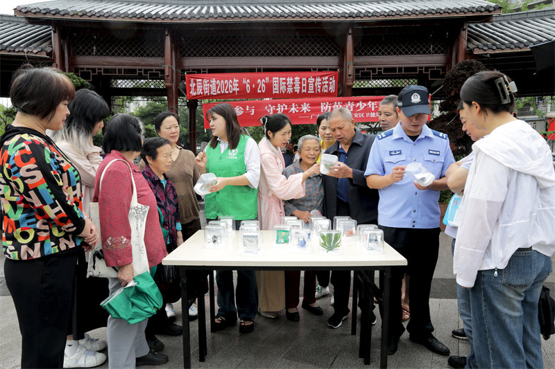 在广安市广安区北辰街道北辰湖广场，民警和禁毒网格员通过展示仿真毒品模型给居民宣传禁毒知识。