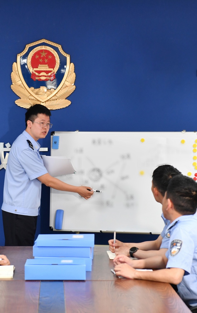 资阳市公安局网络安全保卫支队三大队副大队长李捷兮正在和同事讨论案件。资阳公安供图
