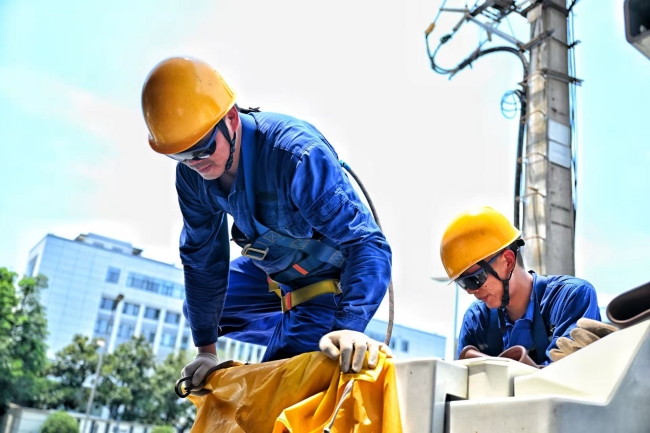 带电作业班成员廖礼钢、李思杨在10千伏汇方线14号杆更换开关作业。袁丹供图