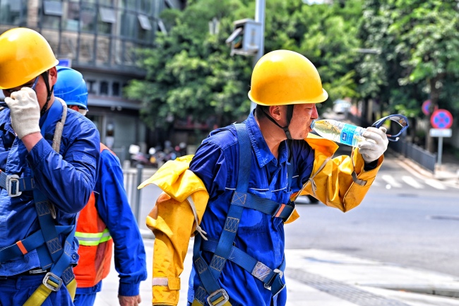 带电作业班成员张陶在更换开关过程中两次登上带电作业斗臂车。袁丹供图
