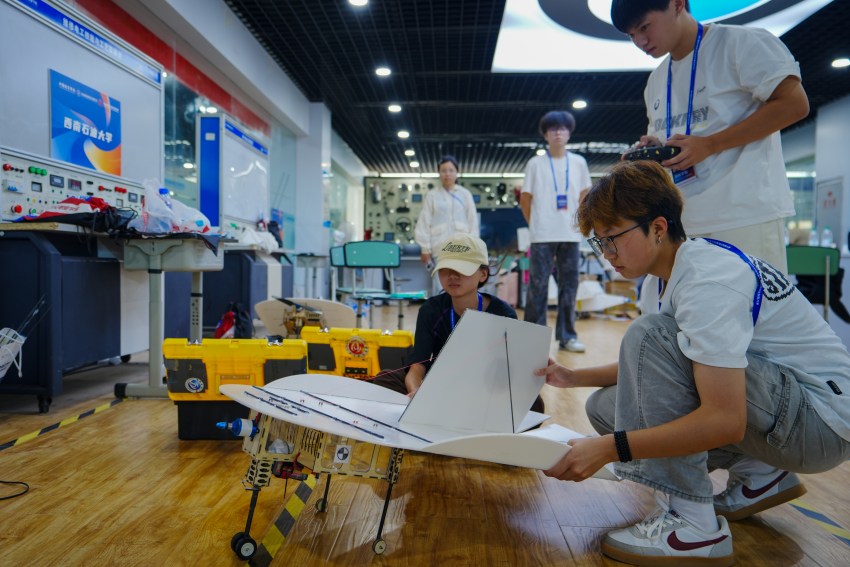 大学生在比赛前调试飞行器。翁光建摄