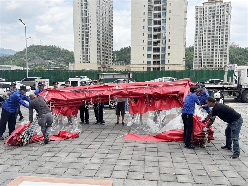 城管工作人员与商家一起清理违章搭建棚。广元市城管执法支队供图