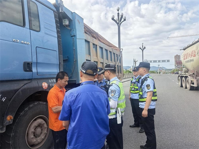 城管工作人员对建筑垃圾清运车辆进行劝导。广元市城管执法支队供图