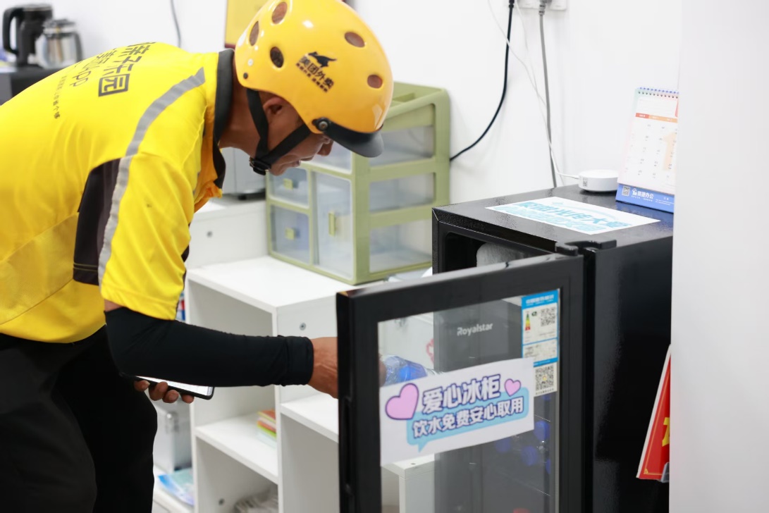 骑手在工行绵阳江油支行的爱心冰柜取用免费饮用水。工行四川省份供图