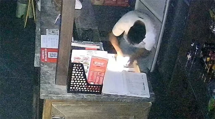蒋某进入店内收银台翻找财物。新都公安供图