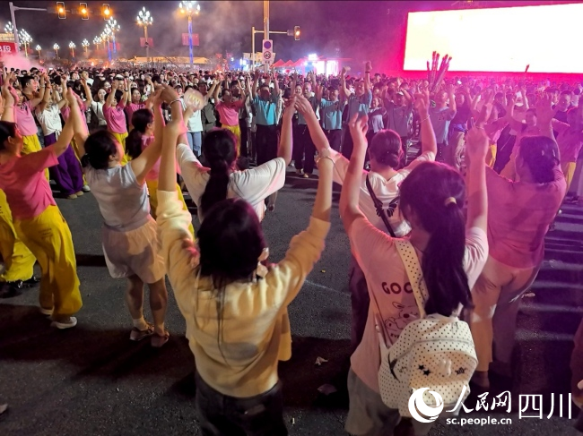 众人手拉手跳起达体舞。实习生 张耀丹摄